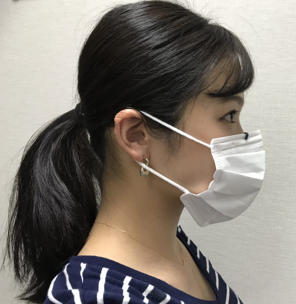 Musha_Kuchimoto」を付けたマスクを着用する女性