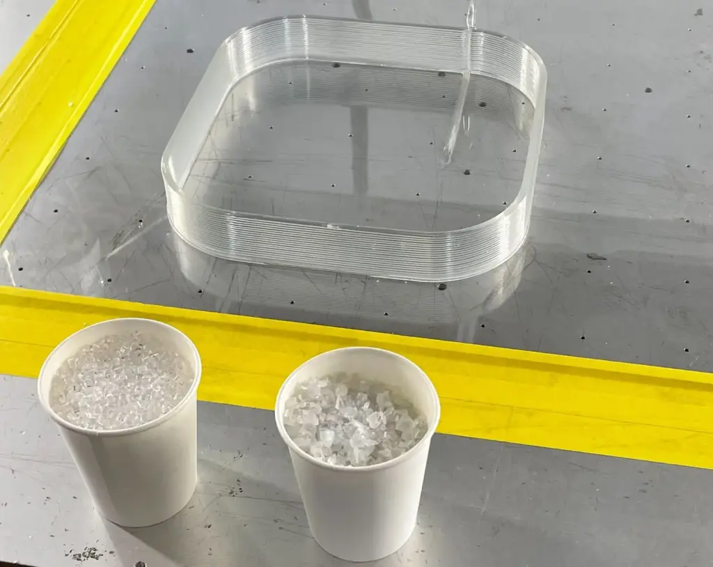 粉剤したプラスチック材を直接投入して3Dプリントしたサンプル。手前のカップは入っているのはペレット材と粉砕材。