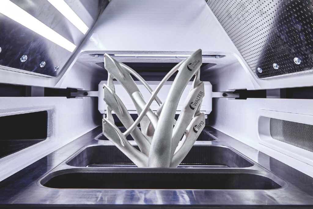 IMPACT 4530積層造形機の造形エリアと完成品の金属部品。（出典：ベッコフオートメーション）