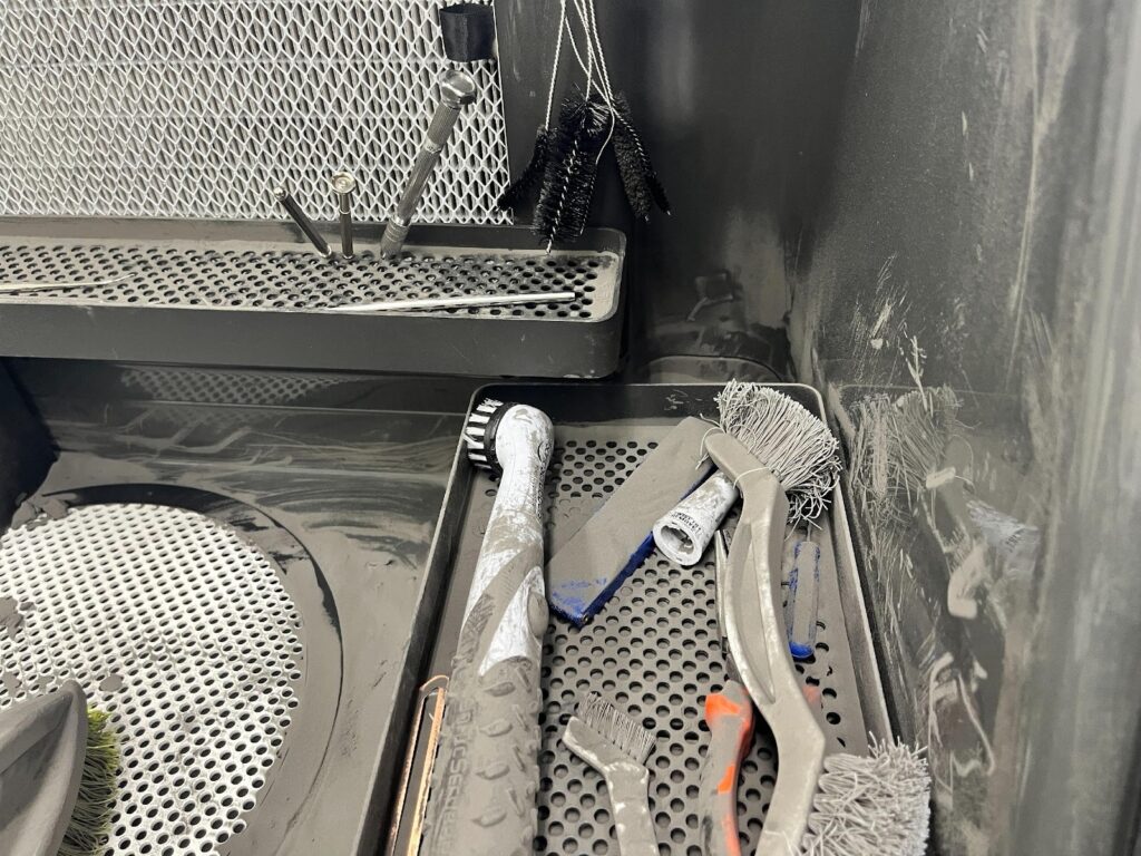 造形を行う部屋は天井も高く空気清浄機も導入され快適な環境。粉末焼結の装置だけあってパウダー除去は専用装置で行う。後工程で使用するFuse Siftは相当使い込まれている様子がうかがえる。 